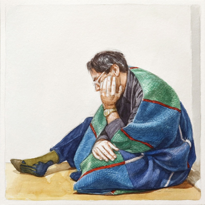 Aquarell: Ein Mann mit Brille sitzt in eine blau-grüne Decke mit roten Streifen gehüllt auf dem Boden und stützt den Kopf in die Hand.